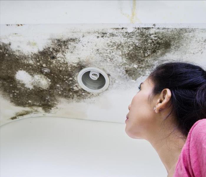 Woman looking at mold in her home. 